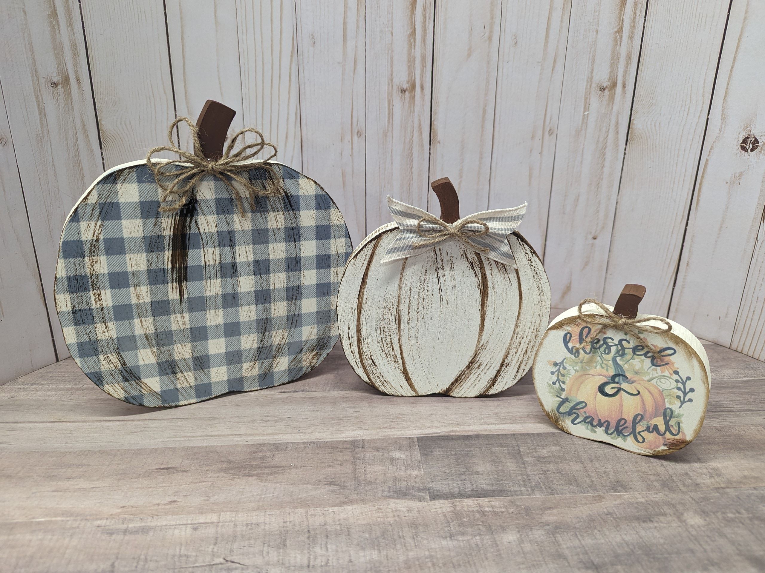 Three Wooden Pumpkins painted in plaid, white and blessed.